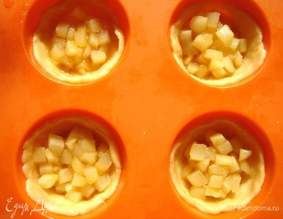 Тесто тонко раскатать.Вырезать по два круга на каждую формочку для кексов:один-по диаметру формы,второй-в два раза больше.Большой круг выложить в форму и распределить по дну и стенкам.Затем добавить 1-1,5 ст.л.начинки.Накрыть маленьким кружком и защипнуть края.