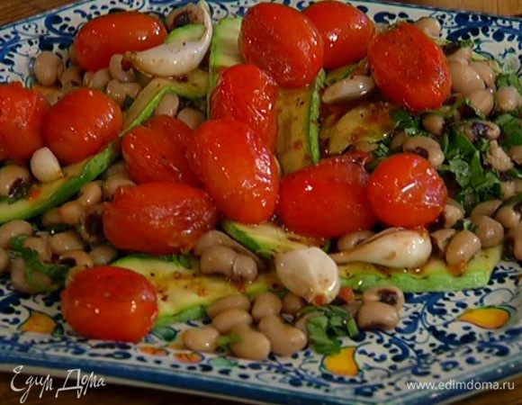 Выложить фасоль на тарелку, сверху разложить цукини и помидоры с чесноком. Полить соком, оставшимся в противне от помидоров.