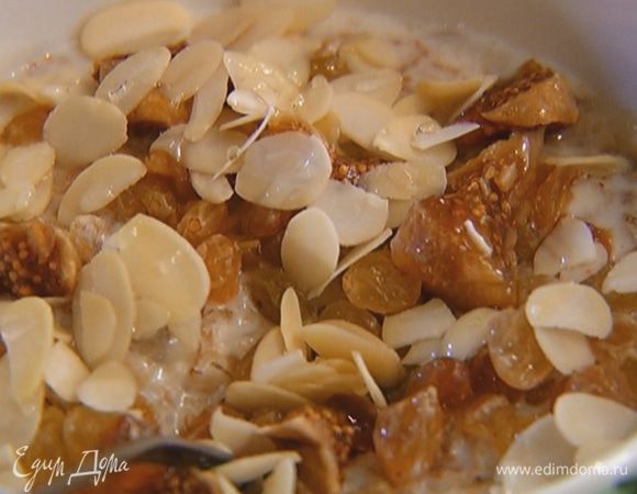 В готовую кашу добавить изюм, инжир и мед, присыпать миндальными лепестками.