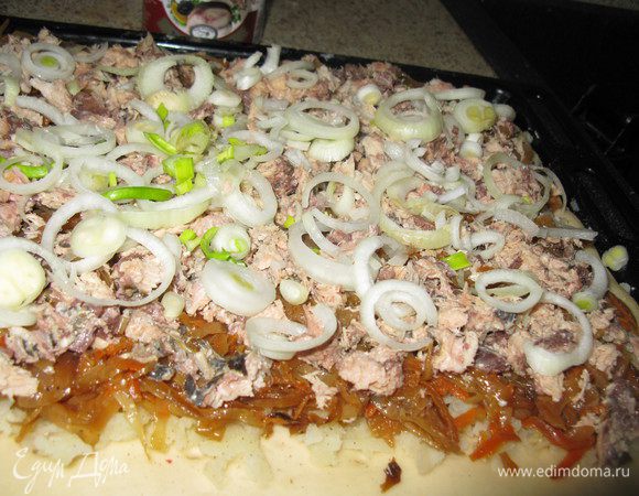  Наколоть тесто вилкой слегка. Положить начинку слоями: сначала тёртую очищенную картошку (обязательно, без неё нельзя), посолить. Потом капусту, поперчить. В конце консервы без жидкости и сырой лук кольцами.