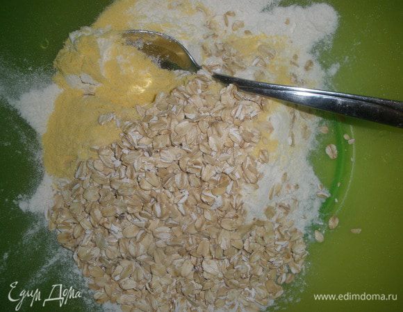 Смешать кукурузную и пшеничную муку с овсяными хлопьями, добавить к маслу. 