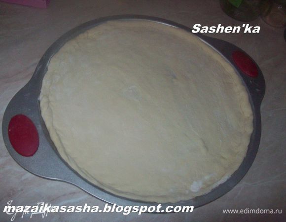 Раскатываем тесто скалкой или разминаем руками. Выкладываем на противень и формируем бортики.