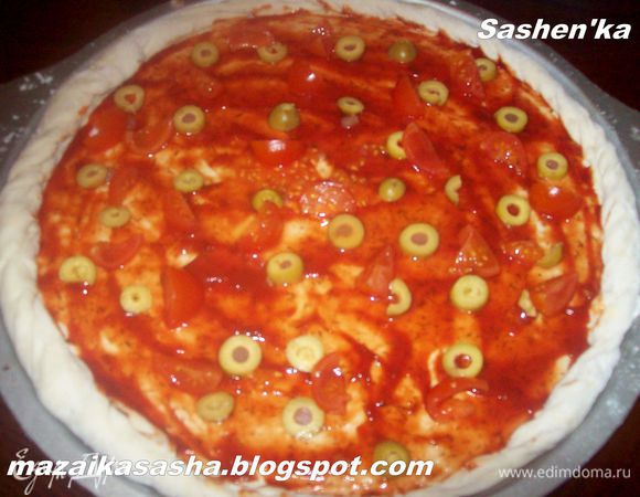 Смазываем тесто Вашим любимым томатным соусом. Оливки режем кружочками. Как я уже говорила, я люблю оливки фаршированные анчоусами, при выпекании пиццы анцоусы растворяются в соусе и делают его еще более вкусным.)