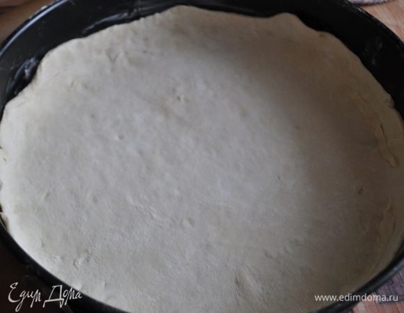 На присыпанной мукой рабочей поверхности раскатать тесто. Вырезать из него круг диаметром чуть больше диаметра формы для выпекания.
Разъемную форму смазать маслом, застелить пергаментом. Тесто аккуратно уложить в форму так, чтобы оно закрывало дно и на 2–3 см заходило на бортики.