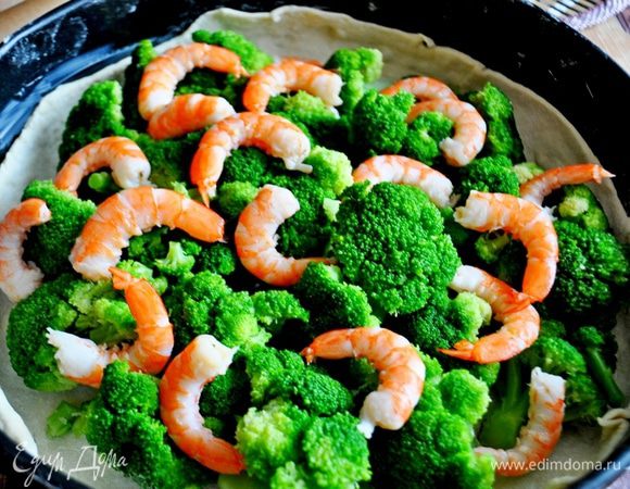Выложить на тесто брокколи и креветки.
