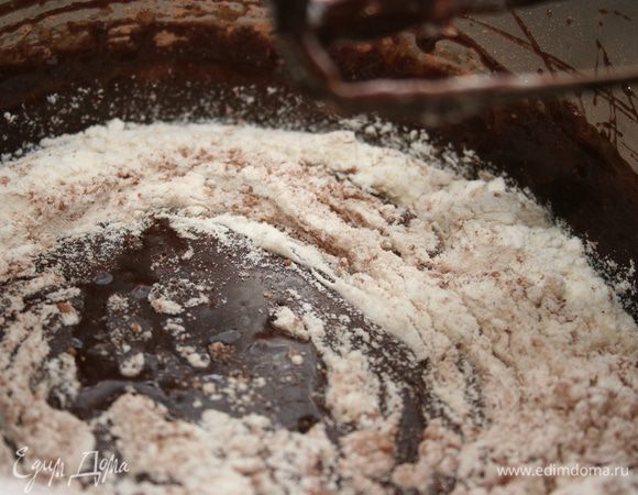 Добавляем шоколад к взбитым яйцами интенсивно перемешиваем, чтобы шоколад не осел на дне. Затем просеиваем муку с какао в смесь и аккуратно смешиваем, избавляясь от комочков. Шоколадный слой готов.