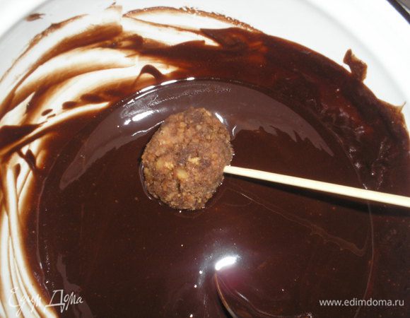 Пирожные вынимаем из морозилки, и по одному окунаем в глазурь. Удобно это делать деревяной длинной шпажкой.