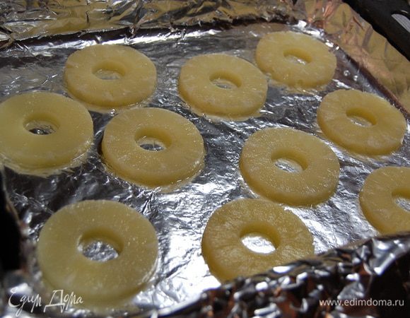 Противень застелить фольгой, смазать её растительным маслом. На фольгу выложить колечки ананасов...