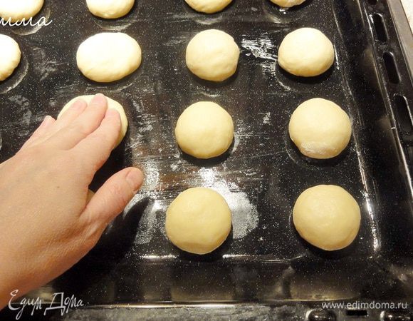 Выложите на смазанный противень и прижмите каждый колобок. Оставьте противень в теплом месте.  