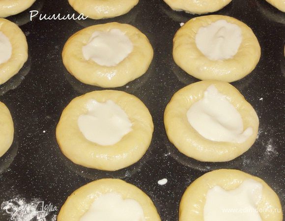 Разложите в центр каждой булочки сметанную массу. Смажьте бока яйцом.
