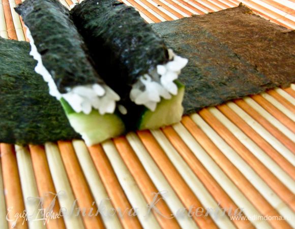 Возвращаемся к коврику. Положить на коврик оставшуюся часть листа. На лист выложить две четвертинки ролла срезами наружу. 