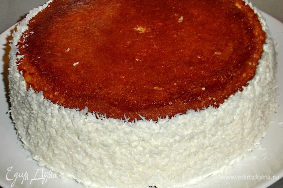 Накрываем второй частью коржа(кремом внутрь)Мажем бока торта кремом,перевернём тарелку так,чтобы торт оказался между двух ладоней и аккуратно прокатываем кремовые бока по тарелке с кокосовой стружкой.