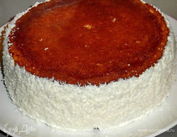 Накрываем второй частью коржа(кремом внутрь)Мажем бока торта кремом,перевернём тарелку так,чтобы торт оказался между двух ладоней и аккуратно прокатываем кремовые бока по тарелке с кокосовой стружкой.