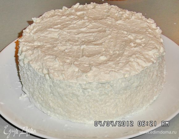 Верхнюю часть тоже пропитаем пропиткой и намажем густо кремом.Аккуратно разровняем поверхность ножом и посыпем кокосовой стружкой.