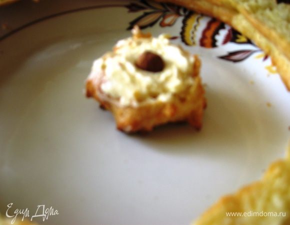 Профитроли разрезаем пополам. Наполняем белым кремом, кладем орешек в серединку (по желанию).