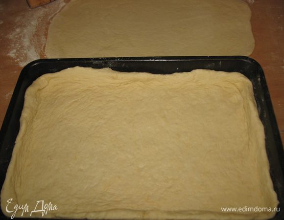 Раскатать большую часть по размеру формы и немного с запасом на бортики. У меня размер формы 23х34. Смазать маслом и выложить в него раскатанную большую часть теста, сформировав бортики. Раскатываем по размеру формы меньшую часть теста. Опять накрываем влажным полотенцем и оставляем отдыхать.