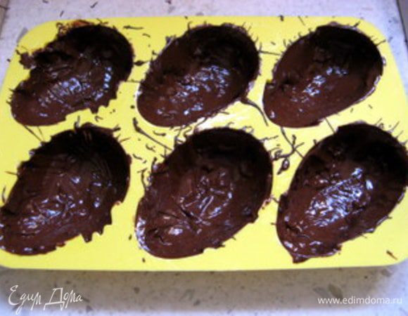 Силиконовые формочки-яйца покрыть толстым слоем шоколада. Для этого удобно использовать силиконовую кисть. Поставить смазанные шоколадом формочки в холодильник, пока готовится крем