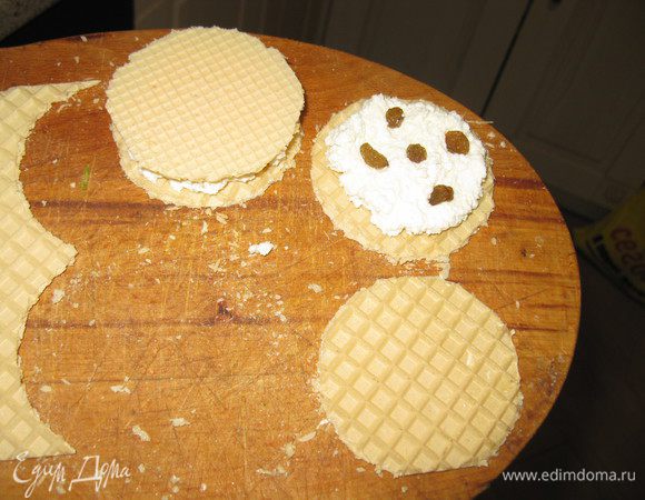 Творог смешать с сахаром, солью,добавить изюм. Если творог очень сухой растереть, если обычный-просто перемешать с сахаром.Лучше если он крупками и посуше. На кружок вафельный положить творог, вторым накрыть.