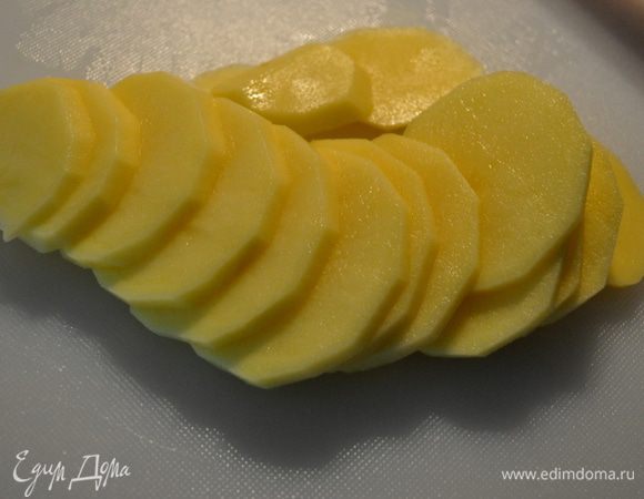 Режем очень острым ножом картофелину на очень тонкие ломтики.Толщина ломтика — максимум 2 мм.
