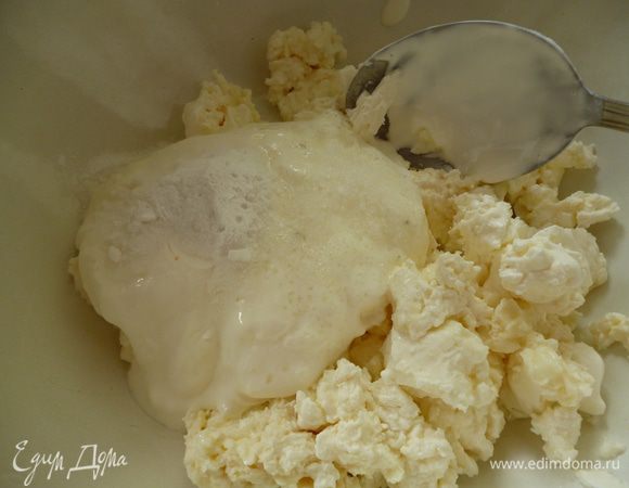 Теперь займемся тестом. В миску выкладываем творог, добавляем сметану, на сметану — соду, перемешиваем ложкой, добавляем соль и хорошо растираем ложкой до однородной массы.