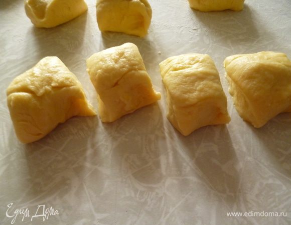 Стол подпылить мукой. Делим тесто на 2 части. Из каждой части раскатываем колбаску толщиной с сардельку, нарезаем каждую колбаску на 10–11 частей.