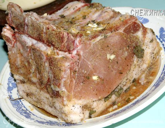 Свинину целиком замариновать. Для этого измельчить вместе сухие травки, чеснок пропустить через пресс, добавить соевый соус, соль, черный молотый перец. Обмазать маринадом мясо.