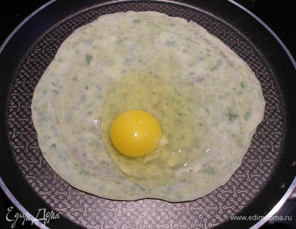 Готовый блинчик кладем на сковороду, которую следует смазать сливочным маслом (или растительным, как вам нравится), сразу разбиваем на него яйцо, солим и перчим. Можно и сыром посыпать, но я делаю это потом.