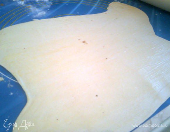 Тесто тем временем раскатать на присыпанной мукой плоскости.Раскатанное тесто, разрезать на 2 равные части.