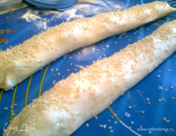Свернуть в рулет.Смазать рулет желтком, посыпать обильно кунжутом.