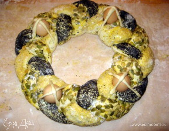 Из отложенных в сторону 150 гр теста сделать тонкие полоски. 
Разместить 4 сырых яйца в косе и закрепить их на косе скрещенными полосками теста. Оставить минут на 15-20, чтобы коса слегка поднялась и выпекать при 180° около 40-50 минут.

