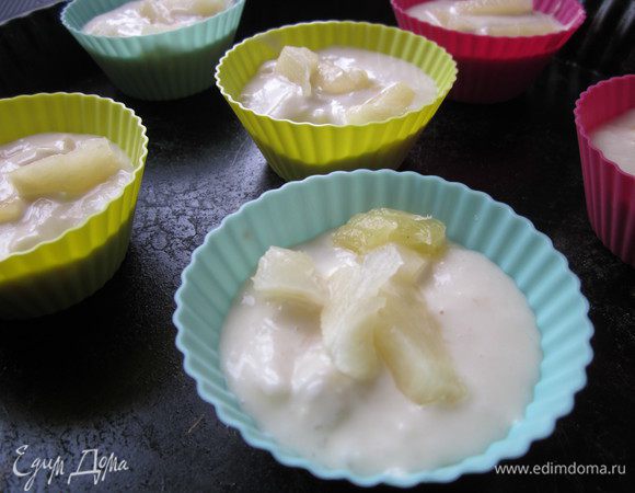 В миску влить 200 мл кокосового молока, 200 г сиропа, кусочки ананасов (оставить часть для верха), мед, растительное масло (предлагалось оливковое, но у меня подсолнечное без запаха) и уксус. Хорошо все размешиваем. Теперь добавляем муку смешанную с содой. Аккуратно перемешиваем, смесь на ваших глазах увеличится в объеме. Раскладываем по формочкам. Я сделала шесть маленьких кексов и один большой кекс в круглой форме. Сверху на тесто выкладываем кусочки ананасов, которые мы отложили.