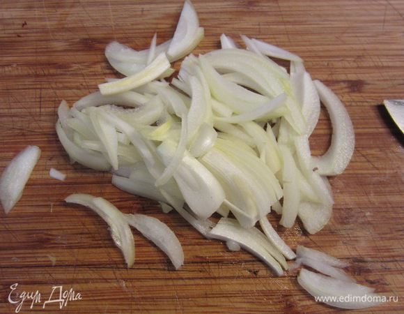 Нарежьте соломкой лук. Для этого лук разрежьте пополам, срежьте попку и стрелу и нарежьте половинки вдоль луковицы.