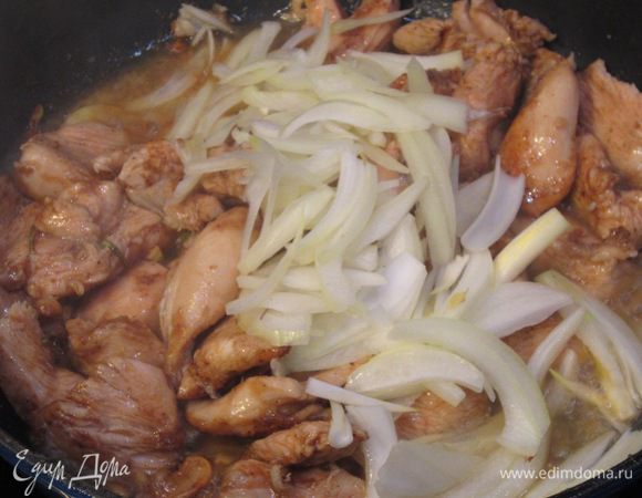 Положите в мясо лук, не переставая интенсивно перемешивать. Через минуту плесните треть стакана кипятка. Тушите около минуты.