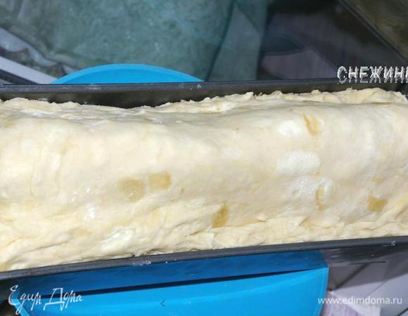 Верхние блинчики смазываем оставшейся сырной массой. Оставшийся кусок теста раскатываем на присыпанной мукой поверхности в прямоугольник, немного меньшего размера и накрываем сверху. Края двух частей теста скрепляем.