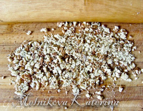 Орехи измельчить скалкой, не слишком мелко. 