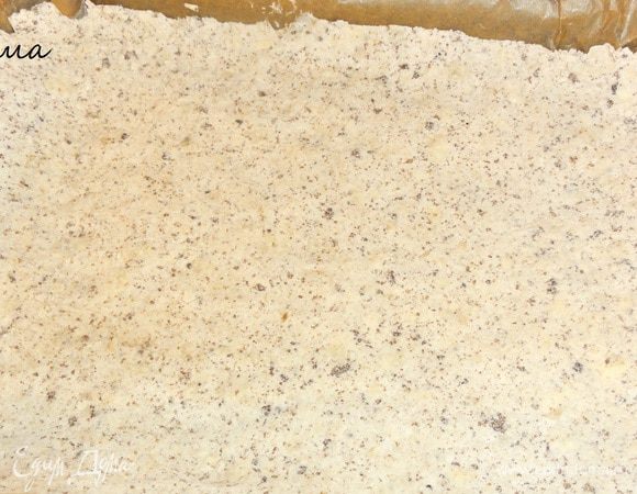 Форму застилаем  бумагой для выпечки. Выкладываем крошку и немного утрамбовываем ее. Ставим основу выпекать на 15 минут.