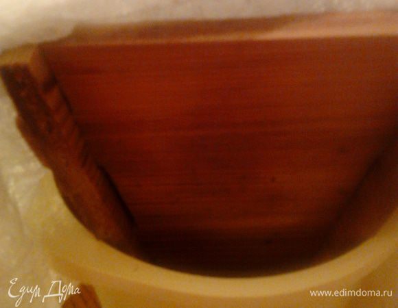 Края марли заложить крест-накрест. Поставить форму с пасхой в миску меньшего диаметра, чтобы жидкость могла стекать, и положить сверху что-то тяжелое.