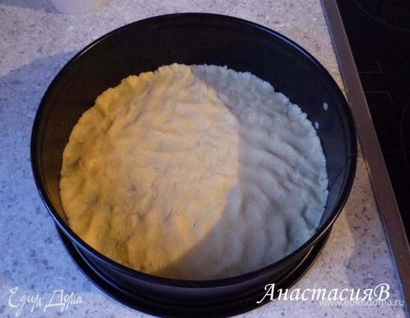 Половину теста раскатать по дну разъемной формы (24-26см), проткнуть вилкой в нескольких местах (я забыла). Поставить на 10 минут в предварительно разогретую до 180°C духовку.