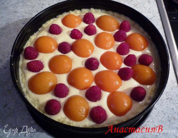 Выложить творожную начинку. Сверху распределить абрикосы и малину. Запечь при той же температуре 60 минут. Достать из духовки и дать остыть в форме.