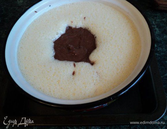 Полученное тесто выливаем по центру кастрюльки с кремом. В процессе выпекания тесто всплывет и равномерно распределится по форме.