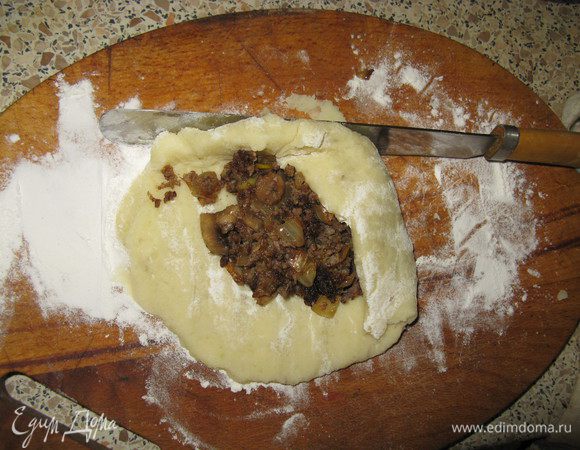 Картошку слить, добавить немного масла, 1 яйцо, никакой жидкости, должно получится густое пюре. Быстро пока горячее делать пирожки. Я не добавляю муку, поэтому надо приноровиться их лепить. Взять часть пюре, положить на посыпанную мукой доску, распределить до толщины 1, 1,5 см, сверху начинка, потом плоским ножом загибать края к центру. Если плохо получается нож можно намочить. Посыпать панировочными сухарями или мукой сверху. Самое сложное снять с доски. Опять же ножом как бы срезать пирожок прямо в руку, а в руках уже доформировать. 