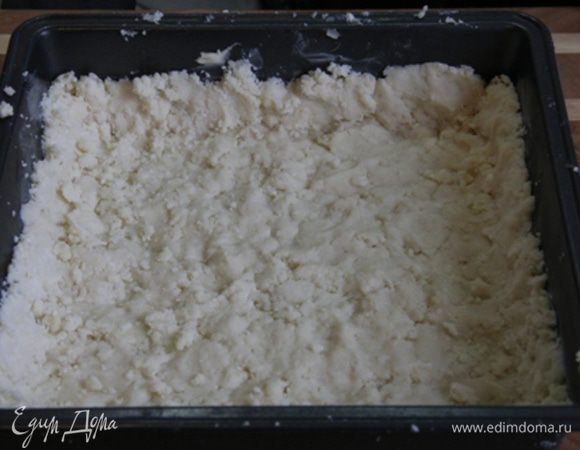 Чуть больше половины теста выложить в форму для запекания и руками разровнять по форме. Руки можно смачивать в воде (но не сильно), чтобы тесто не прилипало к рукам. По возможности слепите бортик. Можно просто отщипывать куски теста и выкладывать их на дно, приминая. 