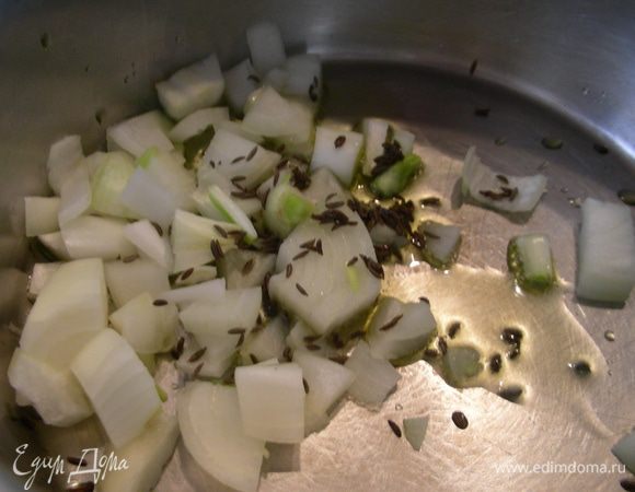 В кастрюле разогреваем оливковое масло и обжариваем пару минут лук и тмин.

