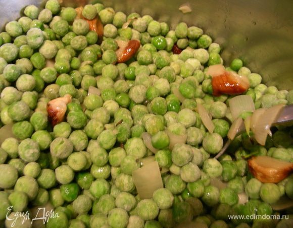 Добавляем зеленый горошек, запеченный чеснок и бульон, доводим до кипения и готовим на небольшом огне минут 8.
