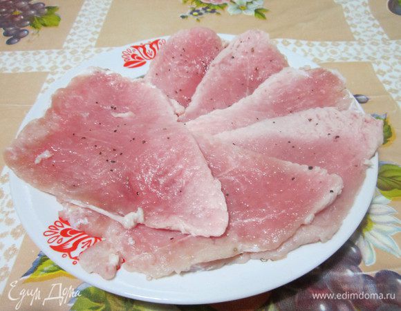 Мясо режем тонкими пластинами, отбиваем, натираем солью, перцем.