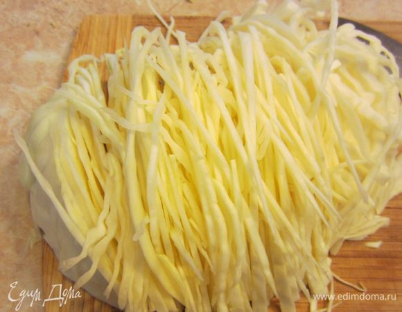 Порежьте капусту на части так, чтобы отделить кочерыжку. Кроме того, я еще срезаю слишком толстые стеблевые утолщения с верхних листьев (но это необязательно). Нарежьте тонко капусту. Я делаю это ножом, но вы можете делать при помощи специальных терок.