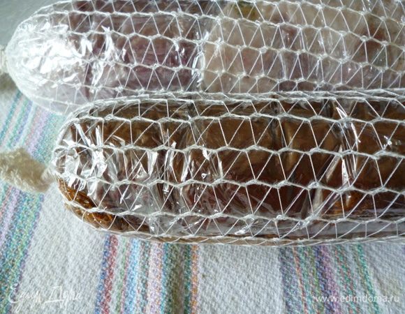 Сверху одеваем сеточку, концы которой завязываем узелком, получается вот такой плотный батон. Можно вместо сеточки плотно перемотать нитками или шпагатом.