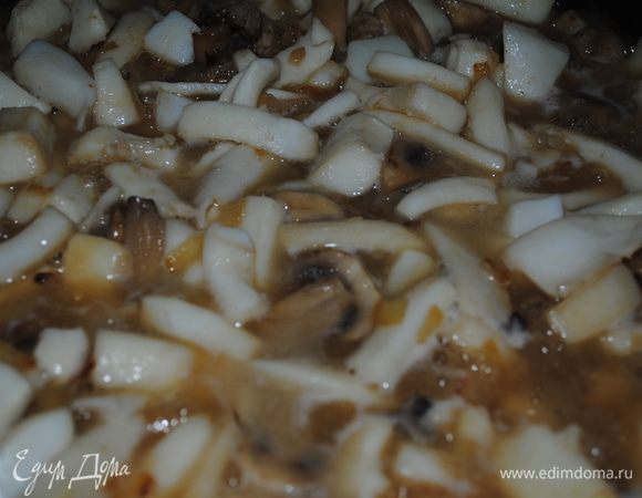 на оливковом масле обжарить порезанный лук, добавить половину измельченного чеснока и когда он пустит свой аромат высыпать на сковородку нарезанные шампиньоны. Подсолить и обжарить все вместе минут 7. После этого добавить кальмары, хорошо перемешать и обжарить еще пару минут, после чего влить вино. прибавить огонь и ждать, пока вино выпарится.