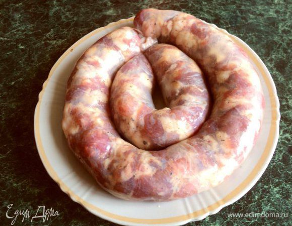 Начините кишки не очень плотно фаршем через воронку, свяжите небольшими колечками. Проткните колбасу тонкой иголкой через каждые 5–7 см. Это нужно для выхода воздуха во время отваривания и запекания.