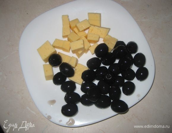 Нарезаем сыр кубиками, оливки отцеживаем.